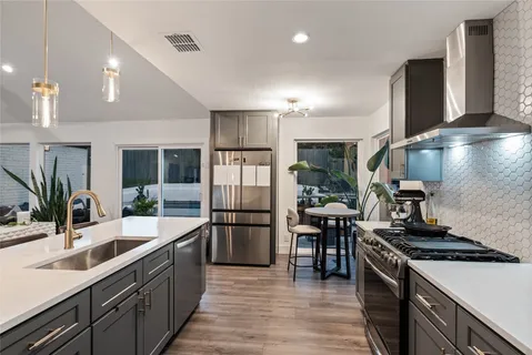 a kitchen with stainless steel appliances granite countertop a sink stove and refrigerator