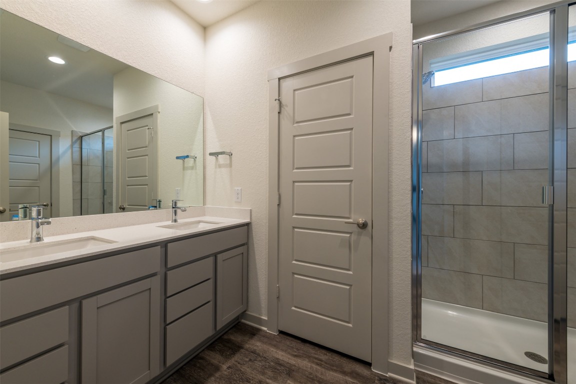 289 Deserti Road Leander, TX 78641 - Photo 9 of 19 a bathroom with a double vanity sink a mirror and a shower