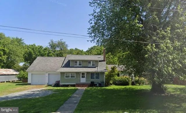 a view of a house with a big yard and large trees