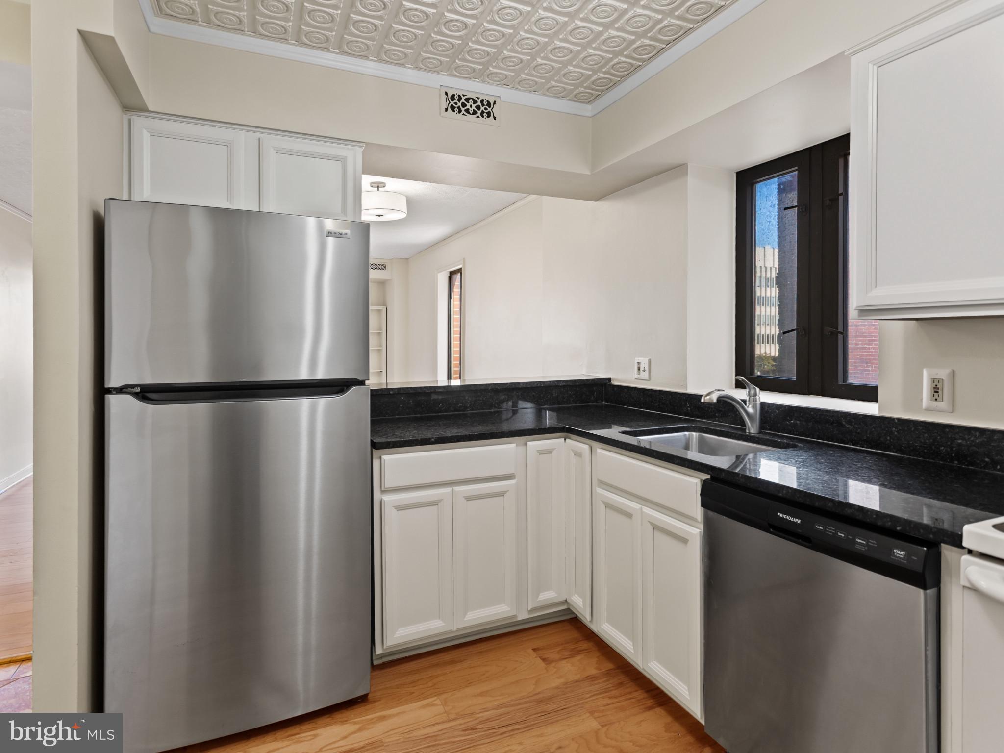 2320 Wisconsin Avenue Northwest, Unit 206 Washington, DC 20007 - Photo 7 of 32 a kitchen with a refrigerator sink and cabinets