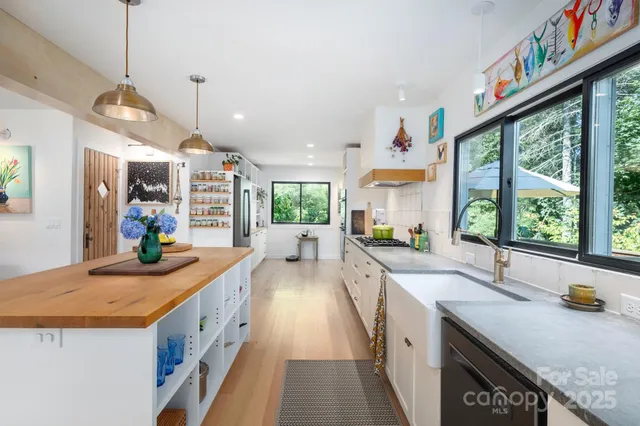 a kitchen with stainless steel appliances granite countertop a stove and a large window