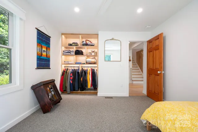 a view of walk in closet with clothes and shoes