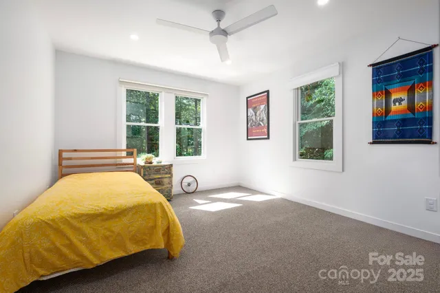 a bed sitting in a spacious bedroom next to a window