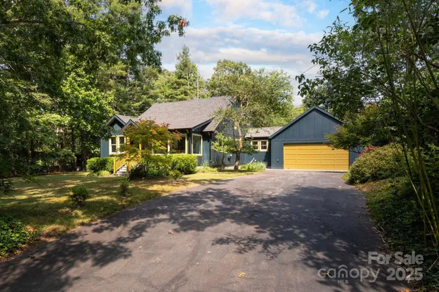 a front view of a house with a yard and trees