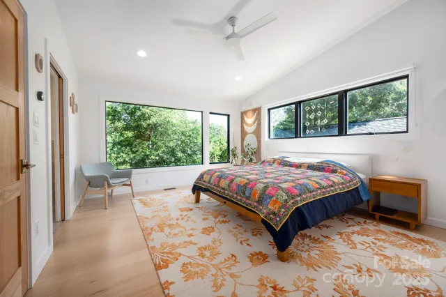 a bed sitting in a spacious bedroom next to a window