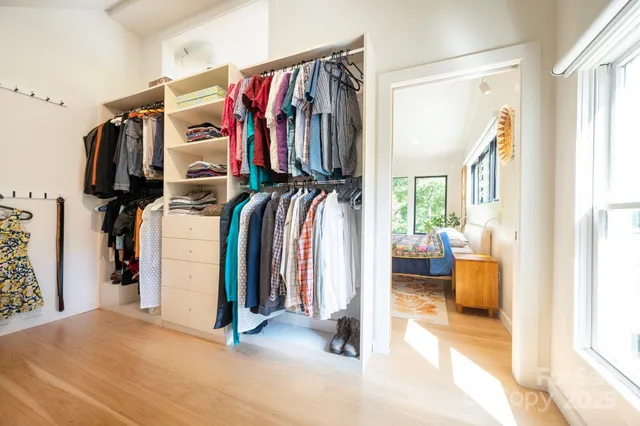 a view of walk in closet with clothes and shoes