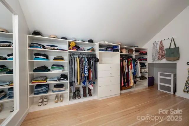 a view of walk in closet with clothes and shoes