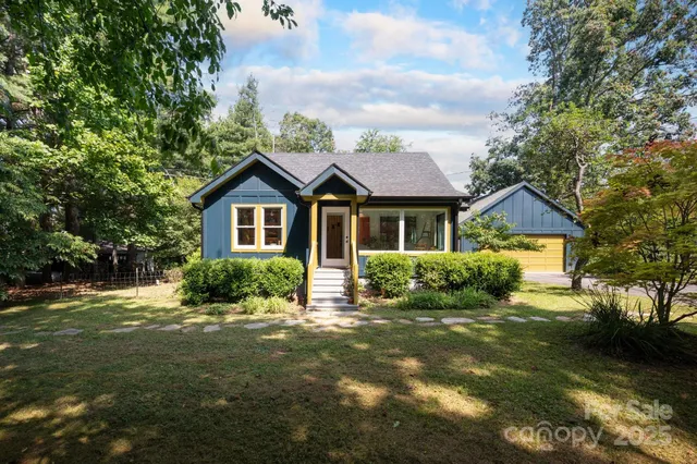 a front view of a house with a yard and green space