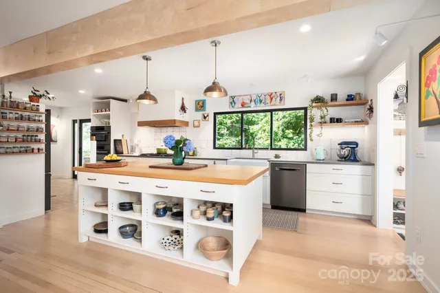 a kitchen with stainless steel appliances a stove a sink and a refrigerator