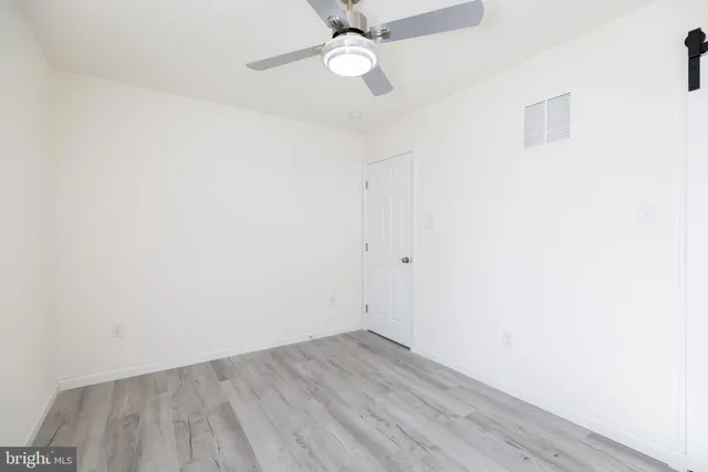 an empty room with a ceiling fan and window