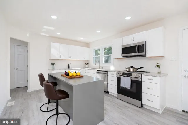 a kitchen with stainless steel appliances a stove sink microwave and cabinets
