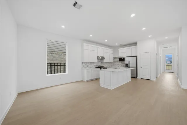 a view of kitchen with stainless steel appliances refrigerator oven and cabinets