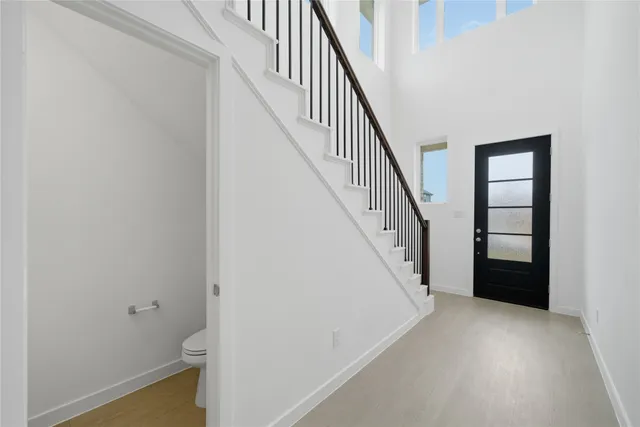 a view of a hallway with wooden floor and staircase