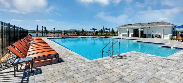 a view of a brick house with a yard and a fountain