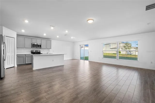 a view of kitchen with wooden floor and electronic appliances