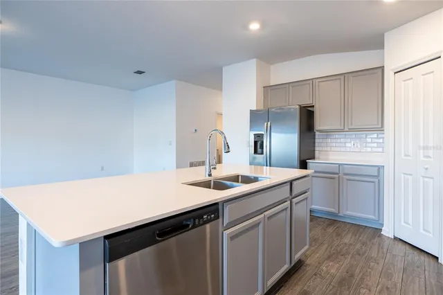 a kitchen with a sink cabinets and wooden floor