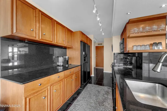 a kitchen with stainless steel appliances granite countertop a sink a stove and a wooden cabinets