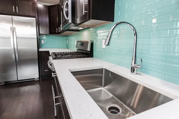 a kitchen with kitchen island a counter space a sink and stainless steel appliances