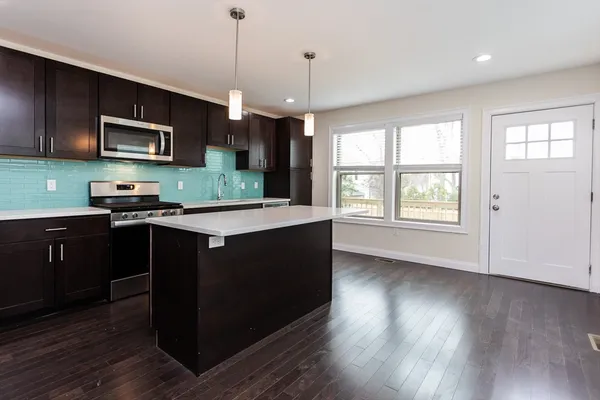 a kitchen with stainless steel appliances granite countertop a stove a sink and a microwave