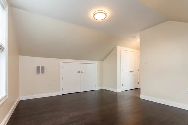 an empty room with wooden floor and window