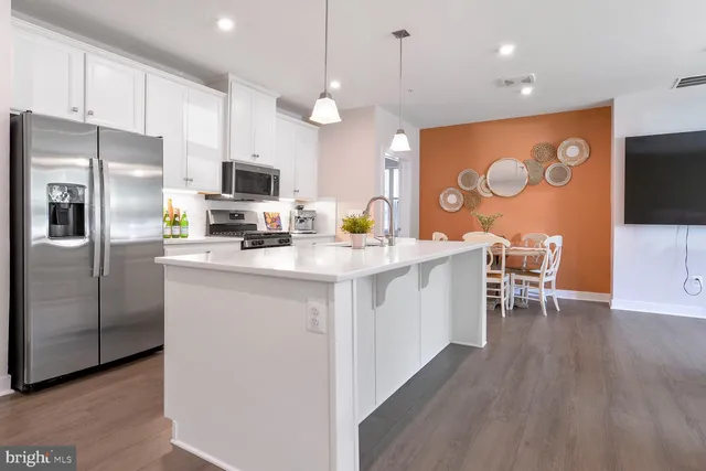 a kitchen with stainless steel appliances a refrigerator and a stove top oven