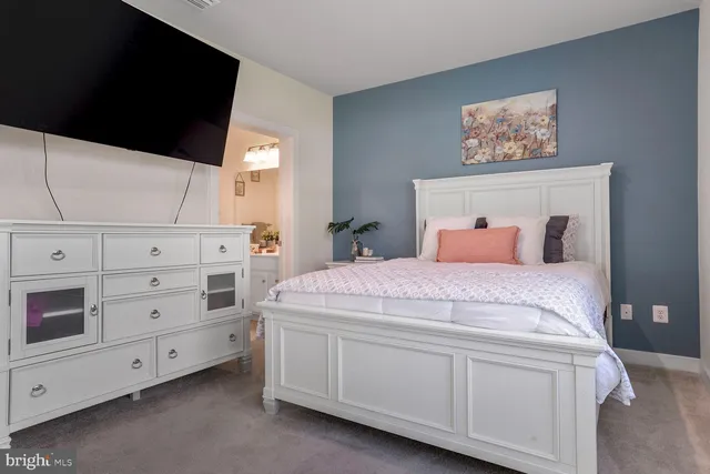 a bedroom with a bed and a tv on dresser