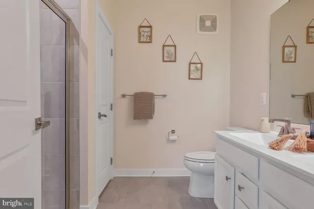 a bathroom with a toilet sink vanity and mirror