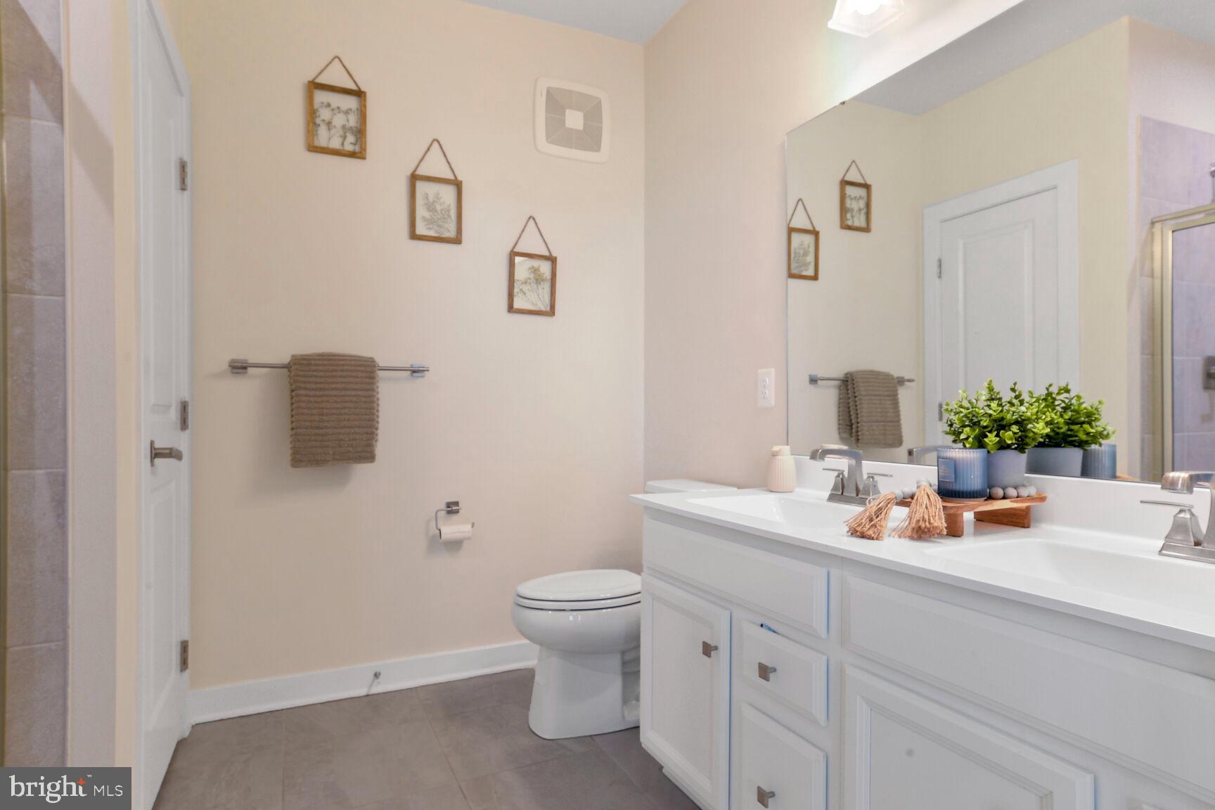 10401 Resort Road, Unit E Ellicott City, MD 21042 - Photo 30 of 44 a bathroom with a toilet a sink and mirror