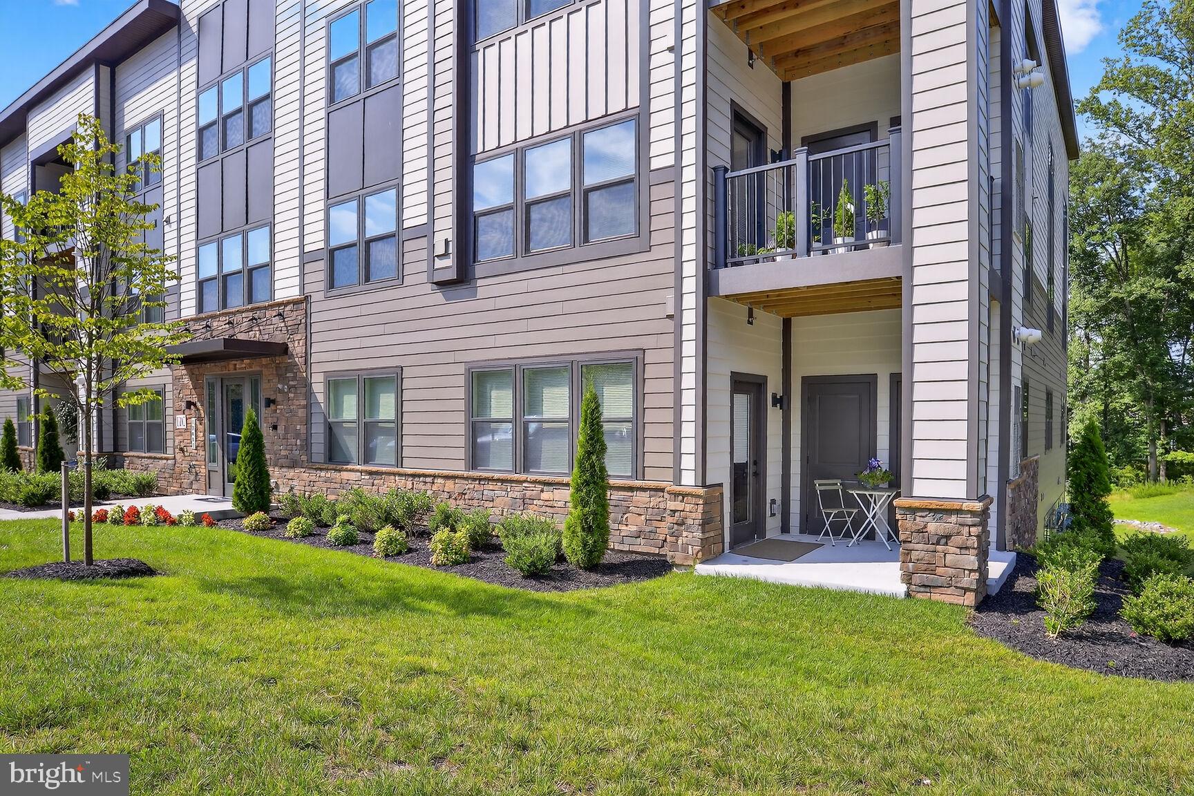 10401 Resort Road, Unit E Ellicott City, MD 21042 - Photo 41 of 44 a view of a house with brick walls and a yard with plants