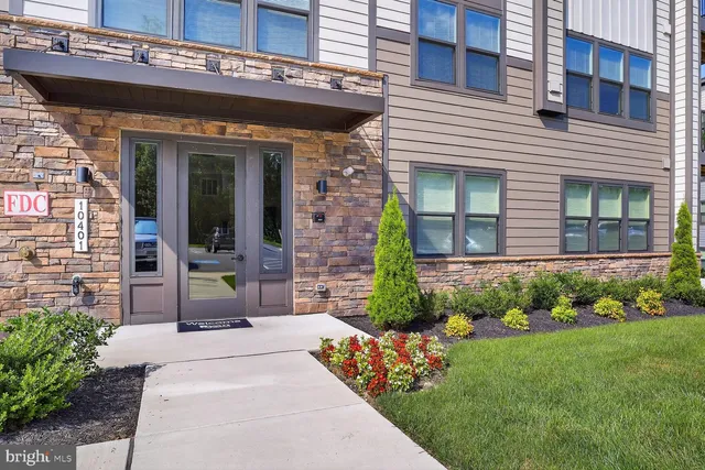 a view of a house with potted plants and a bench
