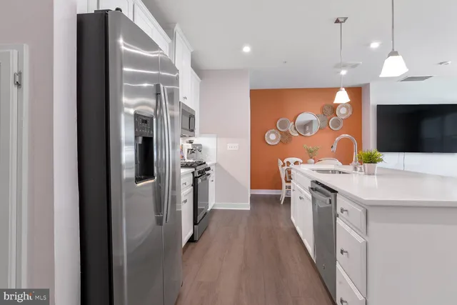 a large kitchen with stainless steel appliances granite countertop a sink a refrigerator and a stove