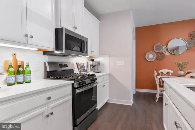 a kitchen with stainless steel appliances a stove a microwave and a hard wood floors