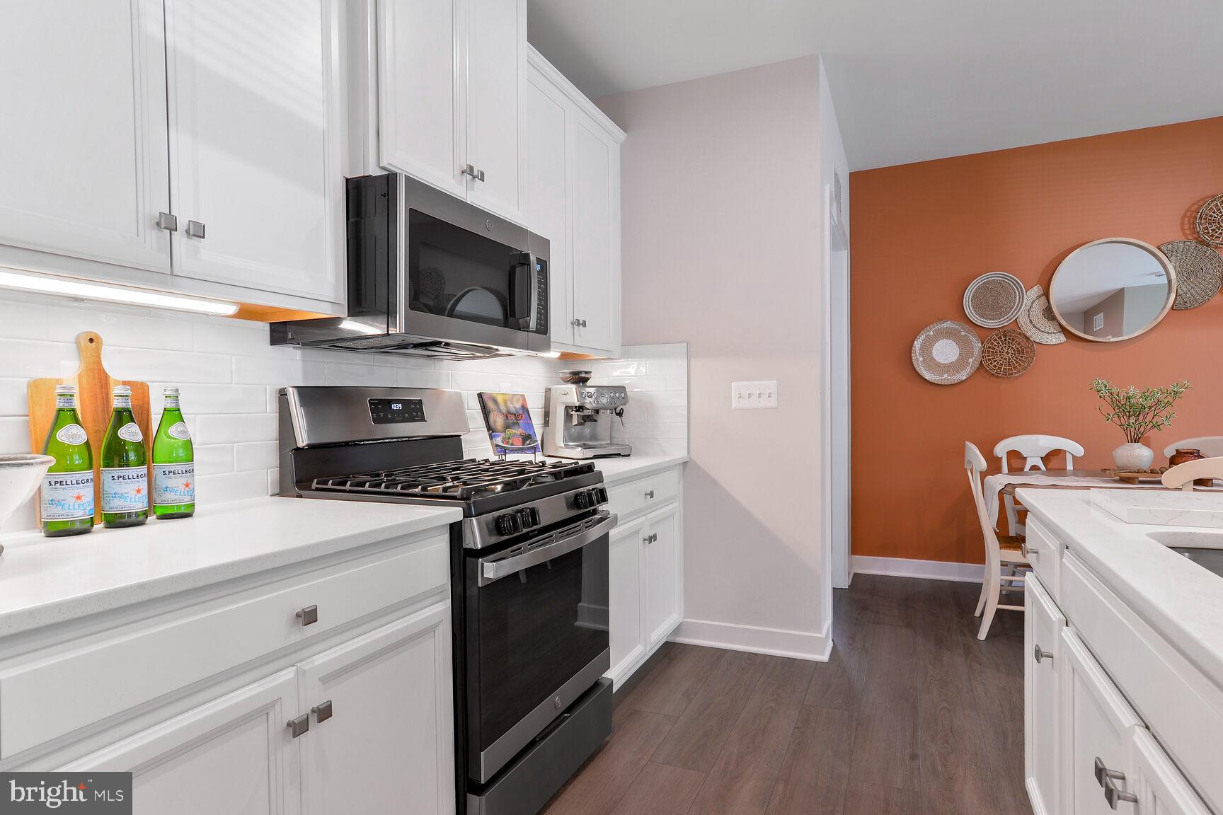 10401 Resort Road, Unit E Ellicott City, MD 21042 - Photo 6 of 44 a kitchen with stainless steel appliances a stove a microwave and a hard wood floors