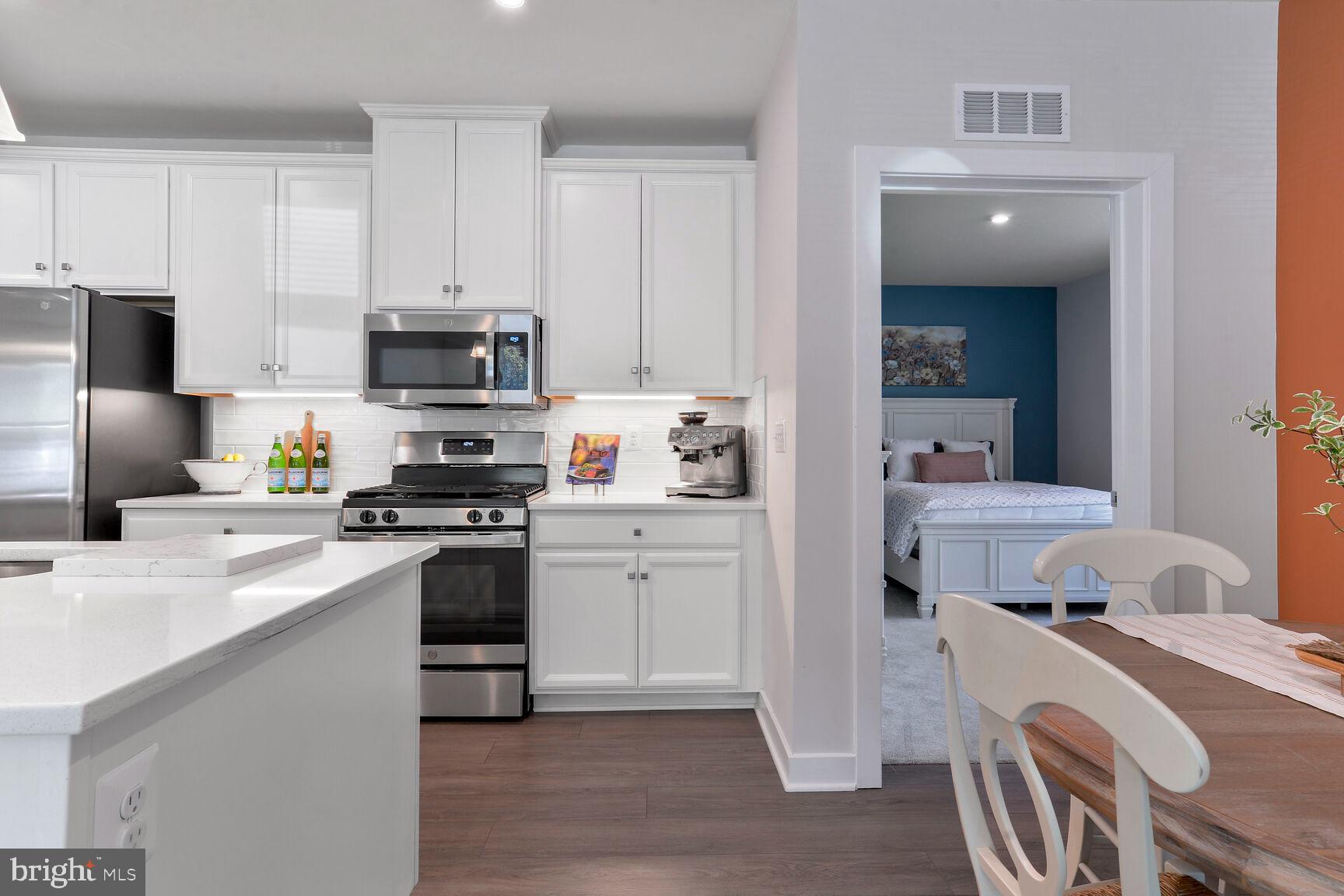 10401 Resort Road, Unit E Ellicott City, MD 21042 - Photo 7 of 44 a kitchen with a sink a stove a refrigerator and white cabinets