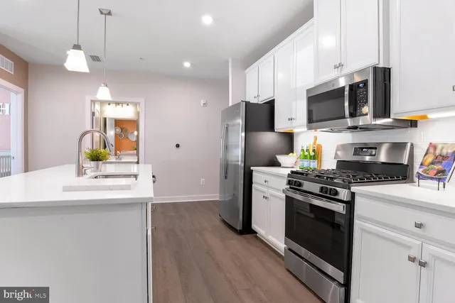 a kitchen with stainless steel appliances a stove microwave and sink