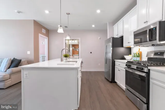 a kitchen with stainless steel appliances a sink stove and refrigerator