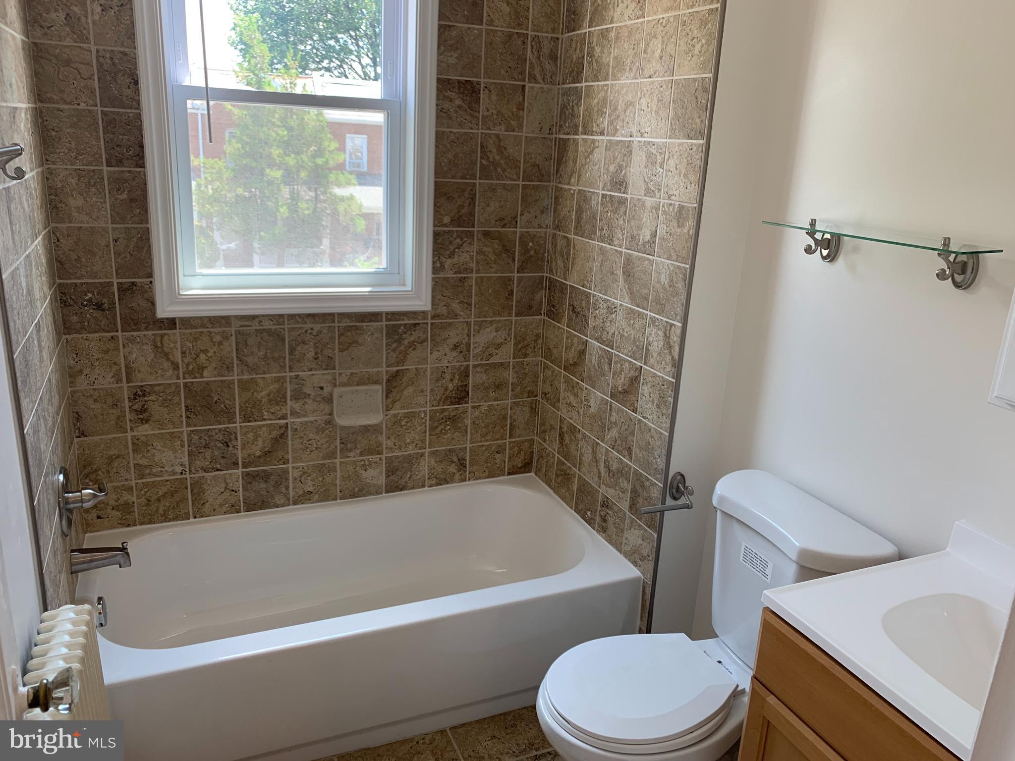 1326 Holbrook Street Northeast Washington, DC 20002 - Photo 19 of 21 a bathroom with a bathtub toilet and window