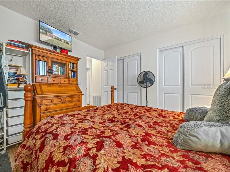 543 Silver Course Court Ocala, FL 34472 - Photo 12 of 21 a bedroom with a bed and dresser with wooden floor