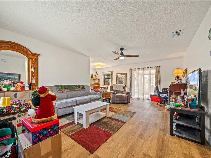 543 Silver Course Court Ocala, FL 34472 - Photo 4 of 21 a living room with furniture a flat screen tv and a floor to ceiling window
