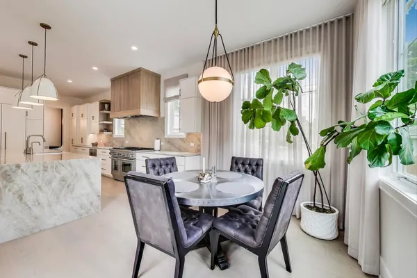 a dining room with furniture potted plants and wooden floor