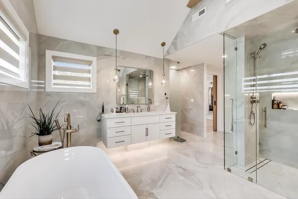a bathroom with a tub sink shower and mirror