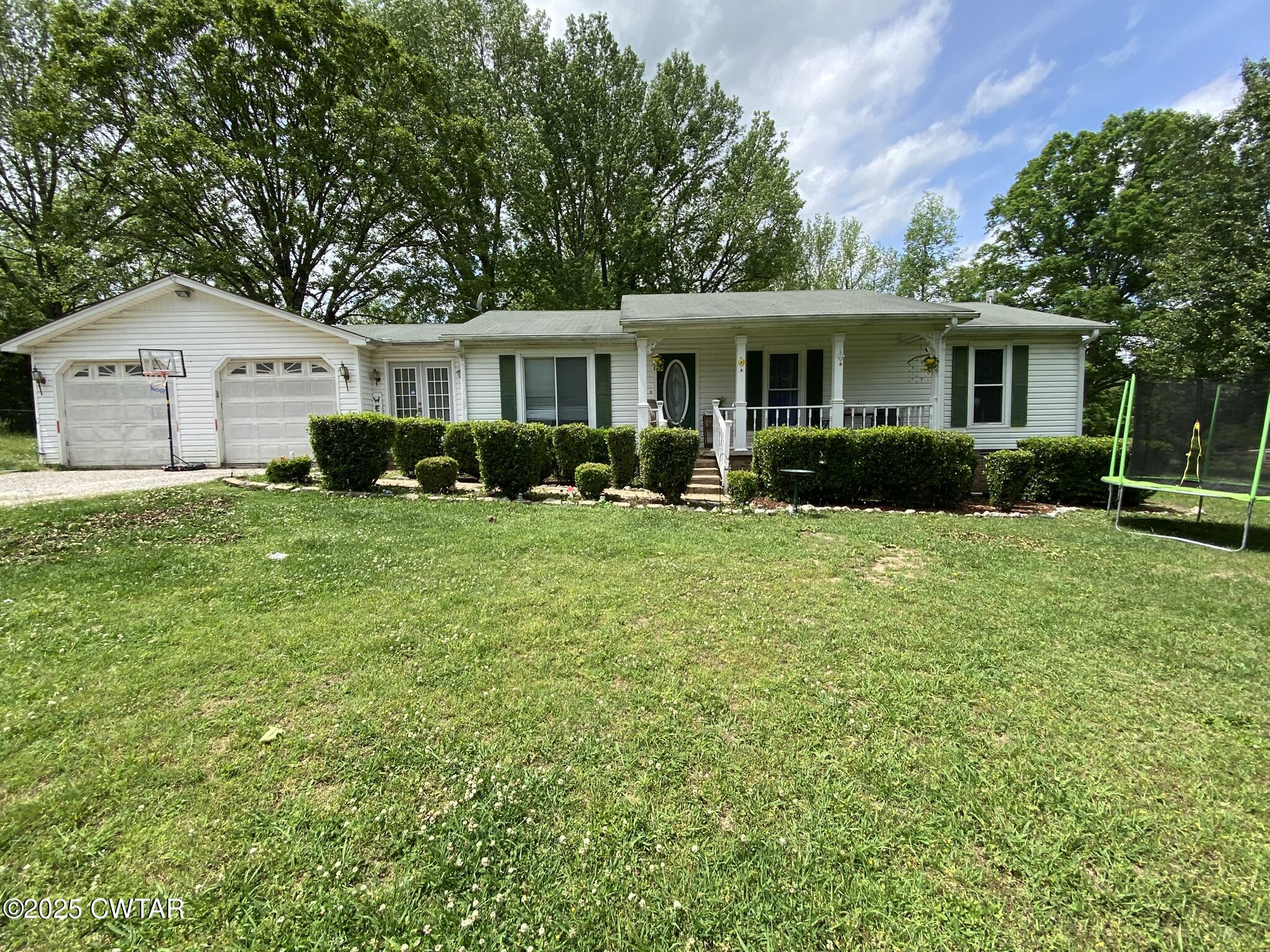 a front view of a house with a yard and trees
