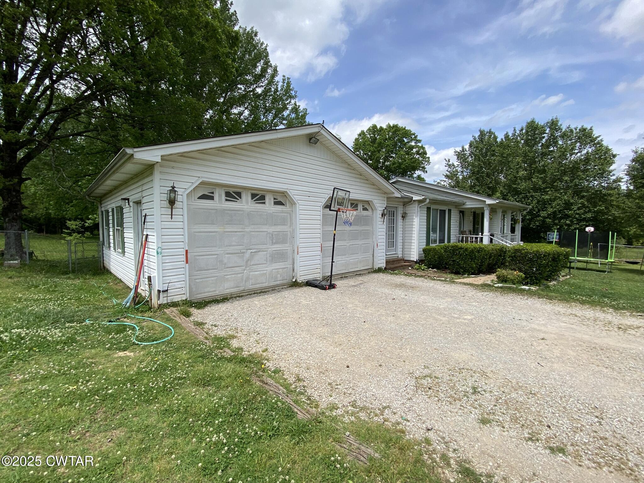 1100 Stewart Road Finger, TN 38334 - Photo 20 of 23 a front view of a house with a yard and garage