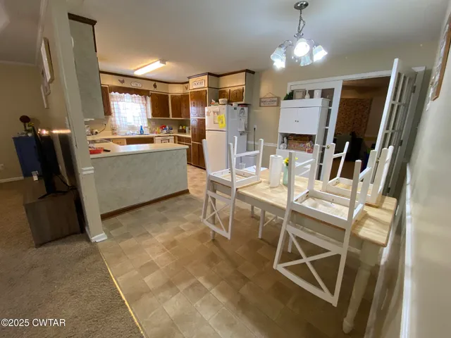 a room with stainless steel appliances kitchen island granite countertop furniture and a refrigerator