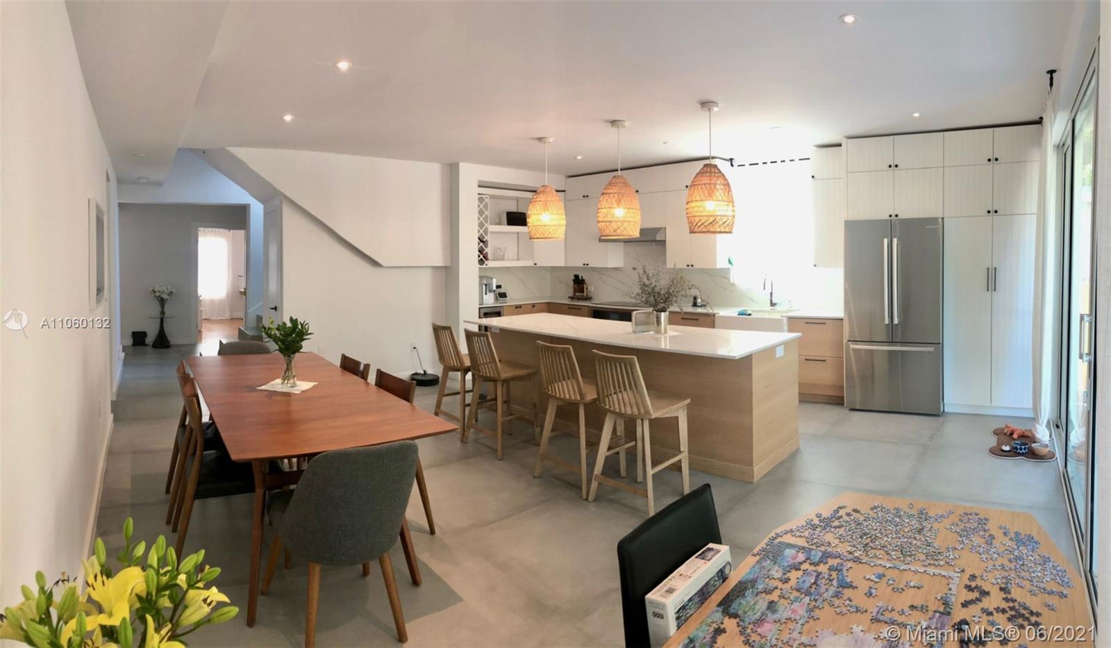 32 Southwest 23rd Road Miami, FL 33129 - Photo 14 of 27 a kitchen with stainless steel appliances kitchen island granite countertop a table chairs and a refrigerator