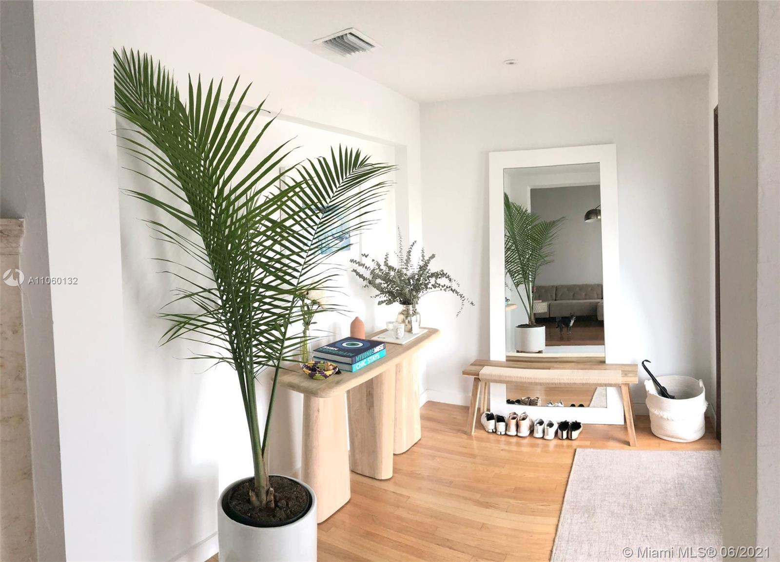 32 Southwest 23rd Road Miami, FL 33129 - Photo 3 of 27 a vase of flowers sitting on a table with a potted plant