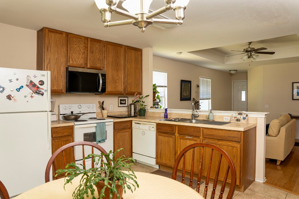 1612 Poppy Seed Lane Austin, TX 78741 - Photo 18 of 18 a kitchen with stainless steel appliances a stove a sink dishwasher a refrigerator with a dining table and chairs with wooden floor