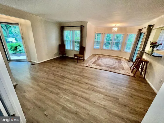 a view of a room with wooden floor and windows