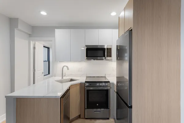 a kitchen with stainless steel appliances a stove microwave and refrigerator