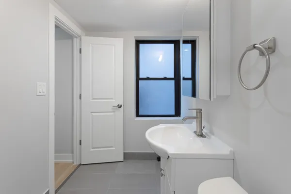 a bathroom with a toilet sink and mirror